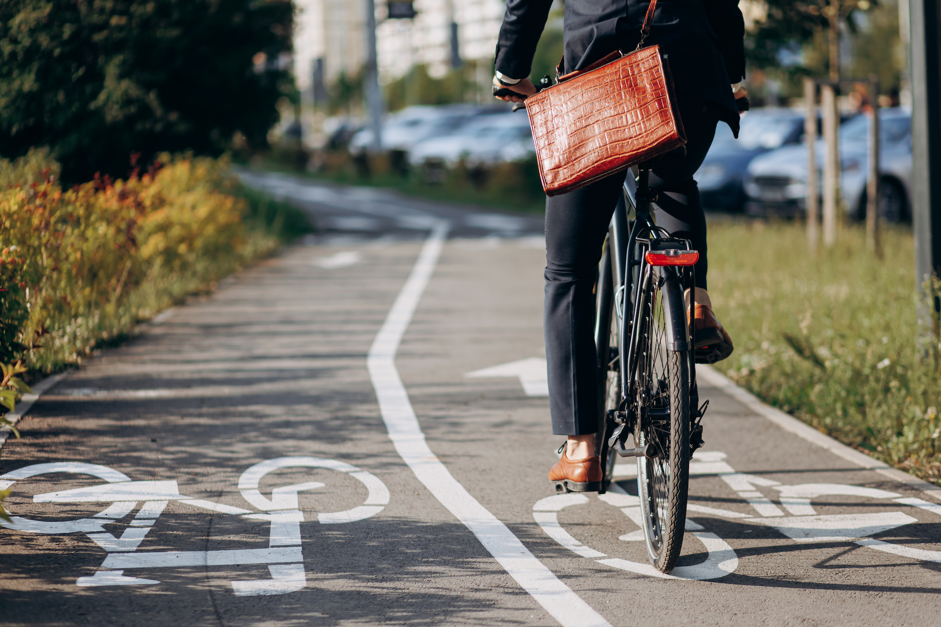Unrecognizable male businessman riding on bicycle track in city.